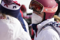 Mikaela Shiffrin of United States, right, stands in the mixed zone near the finish area after skiing off course during the first run of the women's giant slalom at the 2022 Winter Olympics, Monday, Feb. 7, 2022, in the Yanqing district of Beijing. (AP Photo/Luca Bruno)