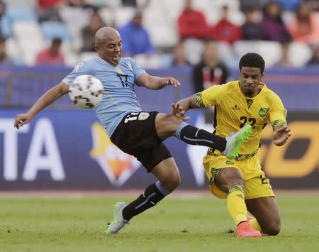 Uruguay's Egidio Arevalo Rios (L) fights for the ball with Jamaica's Garath McCleary during their first round Copa America 2015 soccer match at Estadio Regional Calvo y Bascunan in Antofagasta, Chile, June 13, 2015. REUTERS/Jorge Adorno