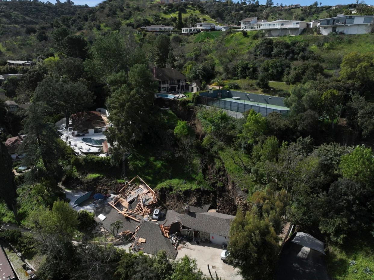 An aerial view shows a property, bottom, damaged by a landslide, Wednesday, March 13, 2024, in the Sherman Oaks section of Los Angeles.