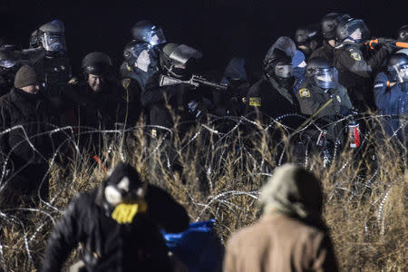 Police confront protesters with a rubber bullet gun during a protest against plans to pass the Dakota Access pipeline near the Standing Rock Indian Reservation, near Cannon Ball, North Dakota. REUTERS/Stephanie Keith