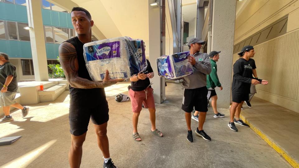 Hawai'i football team members assist in loading donations collected to be sent to Maui residents displaced by the wildfires.
