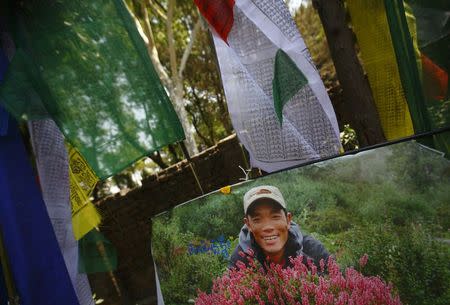A portrait of Ankaji Sherpa, who lost his life in an avalanche at Mount Everest last Friday, is seen near a prayer flag during the cremation ceremony of Nepali Sherpa climbers in Kathmandu April 21, 2014. REUTERS/Navesh Chitrakar