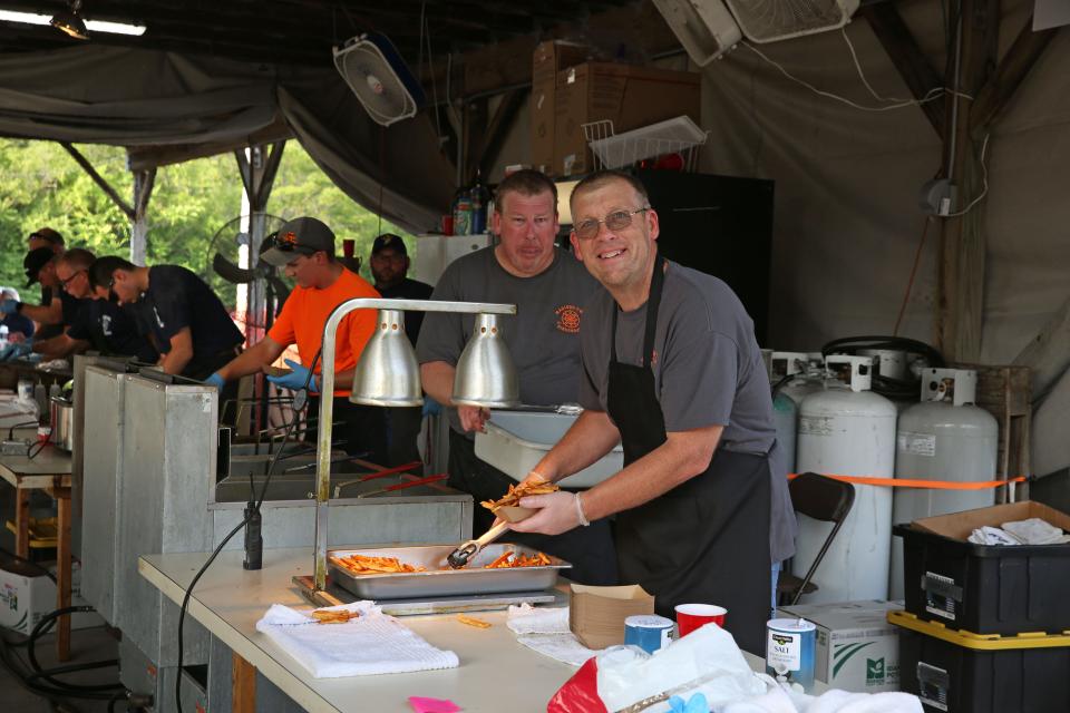 Gibsonburg Volunteer Firemen serve up sandwiches and fresh cut french fries at the Homecoming Fest, which continues through Saturday.