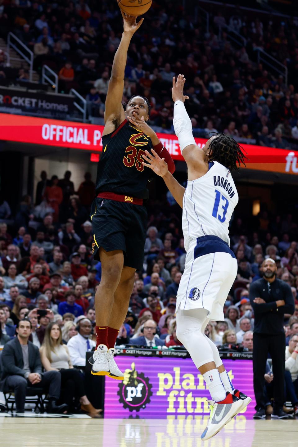 Cleveland Cavaliers guard Isaac Okoro (35) shoots against Dallas Mavericks guard Jalen Brunson (13) during the first half of an NBA basketball game Wednesday, March 30, 2022, in Cleveland. (AP Photo/Ron Schwane)