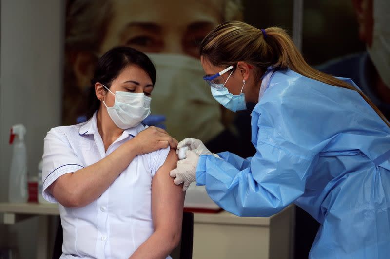 Foto de archivo. Claudia Benavides, enfermera de cuidados intensivos en la Clínica Colombia, recibe una inyección con una dosis de la vacuna COVID-19 de Pfizer-BioNTech en la Clínica Colombia en Bogotá