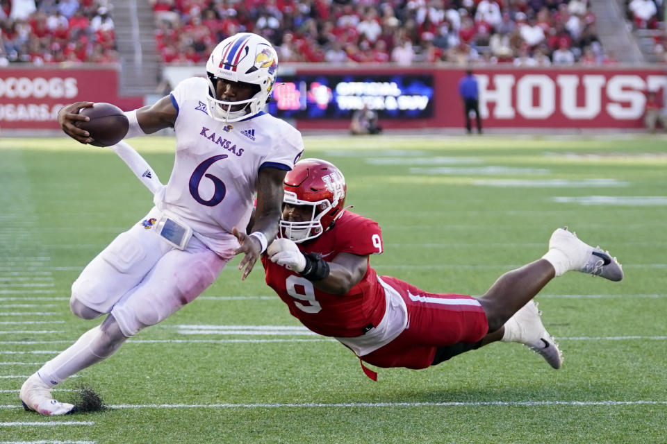 Kansas quarterback Jalon Daniels (6) escapes a tackle by Houston defensive lineman Nelson Ceaser en route to a touchdown during the second half of an NCAA college football game, Saturday, Sept. 17, 2022, in Houston. (AP Photo/Eric Christian Smith)