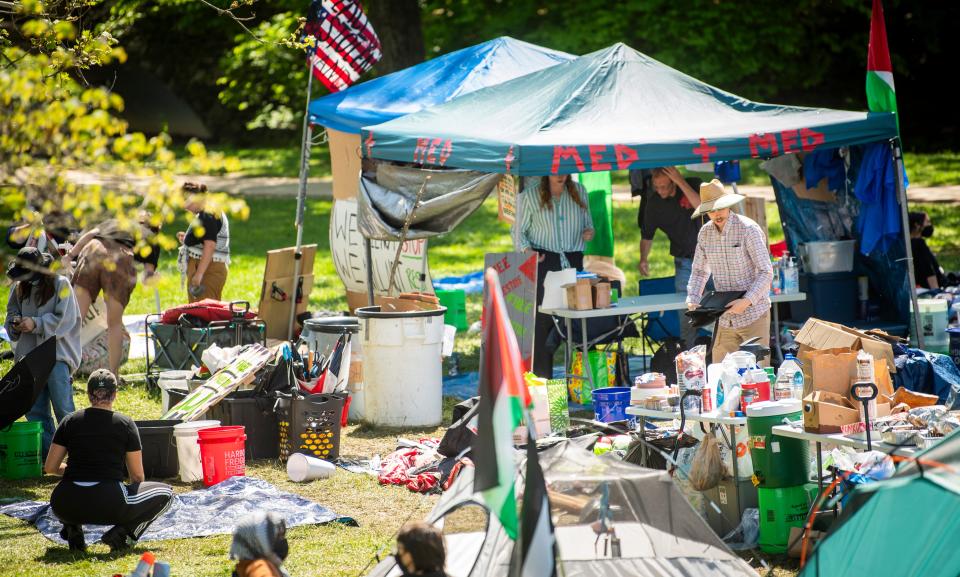 A pro-Palestinian demonstrator organizes materials in Dunn Meadow on Tuesday, April 30, 2024.