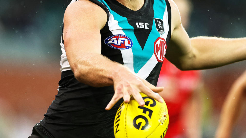 A Port Adelaide player, pictured here in action on the AFL field.