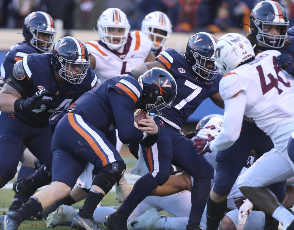 Virginia quarterback Brennan Armstrong (5) rushes for a touchdown in the first half an NCAA college football game in Charlottesville, Va. Saturday Nov. 27 2021. (Matt Gentry/The Roanoke Times via AP)