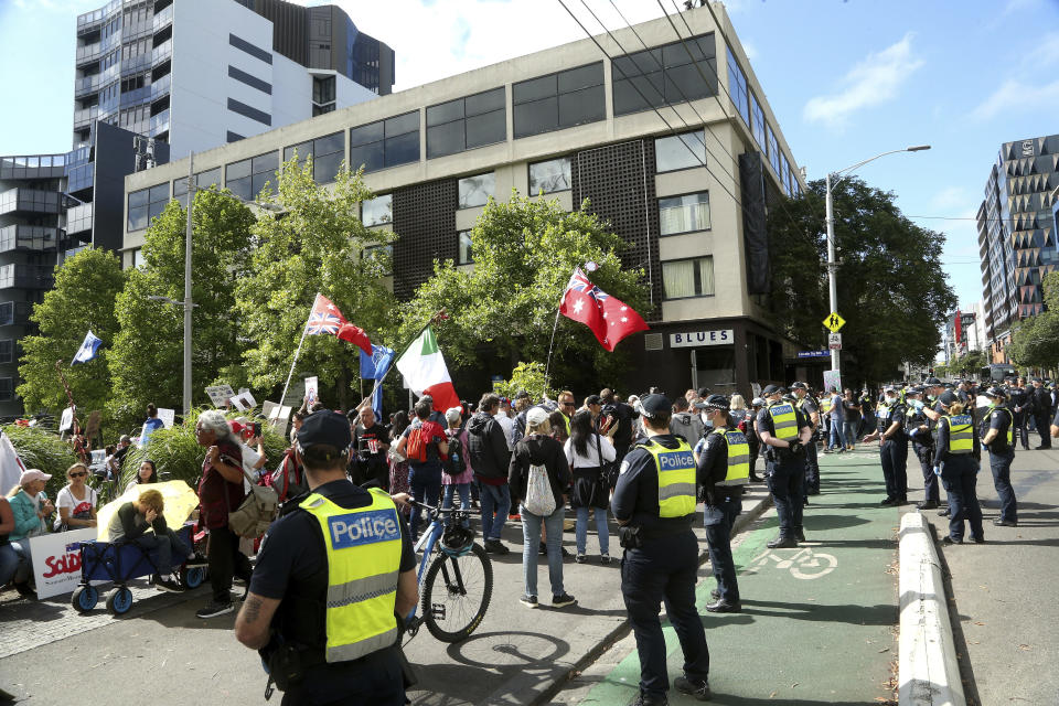 Protesters gather outside the Park Hotel in Melbourne, Australia, Saturday, Jan. 8, 2022. The world’s No. 1-ranked tennis player Novak Djokovic is also being held there after border officials canceled his visa last week over a vaccine requirement. (AP Photo/Hamish Blair)