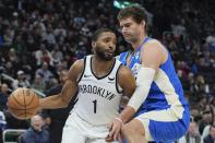 Brooklyn Nets' Mikal Bridges tries to get past Milwaukee Bucks' Brook Lopez during the first half of an NBA basketball game Thursday, March 21, 2024, in Milwaukee. (AP Photo/Morry Gash)