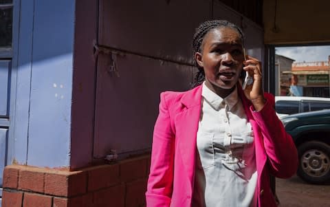 Valentine Nasila, Operations Manager at 4G Capital's head office, speaks with a client in Wangige Town, Kiambu County, Kenya - Credit: Katie G. Nelson&nbsp;/The Telegraph