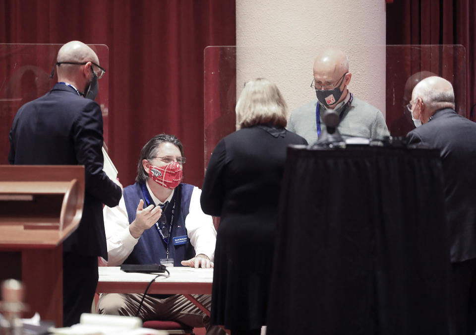 FILE - In this Nov. 20, 2020, file photo, Dane County Clerk Scott McDonell, seated, converses with election workers and legal representatives from the Joe Biden and Donald Trump presidential campaigns as a recount of the 2020 presidential election begins at the Monona Terrace convention center in Madison, Wis. President Trump filed a lawsuit Tuesday, Dec. 1, 2020, in Wisconsin, seeking to disqualify hundreds of thousands of ballots in a longshot attempt to overturn Democrat Joe Biden's win in the battleground state he lost by nearly 20,700 votes. (John Hart/Wisconsin State Journal via AP, File)