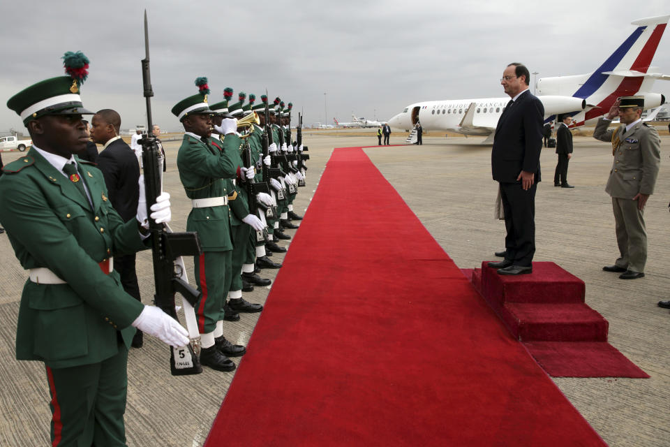 French President Francois Hollande reviews troops as he leaves Abuja, Nigeria's federal capital, en route to Bangui the capital of the Central African Republic, Friday, Feb. 28, 2014. (AP Photo/Philippe Wojazer, Pool)