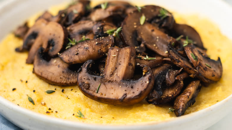 Close up of cooked mushrooms and polenta in bowl
