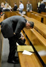 Oscar Pistorius packs up documents for a lunch break in the high court in Pretoria, South Africa, Monday, March 3, 2014. Pistorius is charged with murder with premeditation in the shooting death of girlfriend Reeva Steenkamp in the pre-dawn hours of Valentine's Day 2013. (AP Photo/Herman Verwey, Pool)