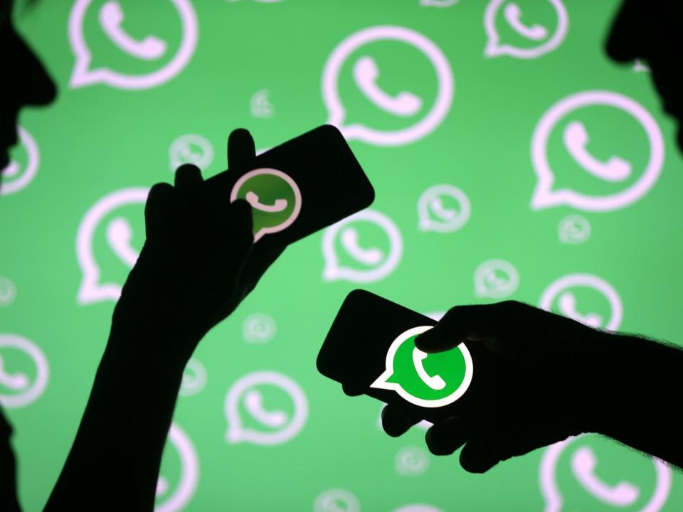 Men pose with smartphones in front of displayed Whatsapp logo in this illustration September 14, 2017: REUTERS/Dado Ruvic