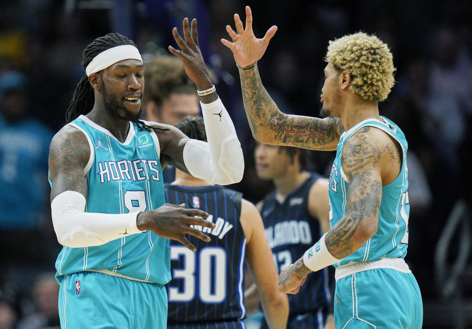 Charlotte Hornets center Montrezl Harrell, left, celebrates a basket with teammate Kelly Oubre Jr., right, during the first half of an NBA basketball game against the Orlando Magic on Thursday, April 7, 2022, in Charlotte, N.C. (AP Photo/Rusty Jones)