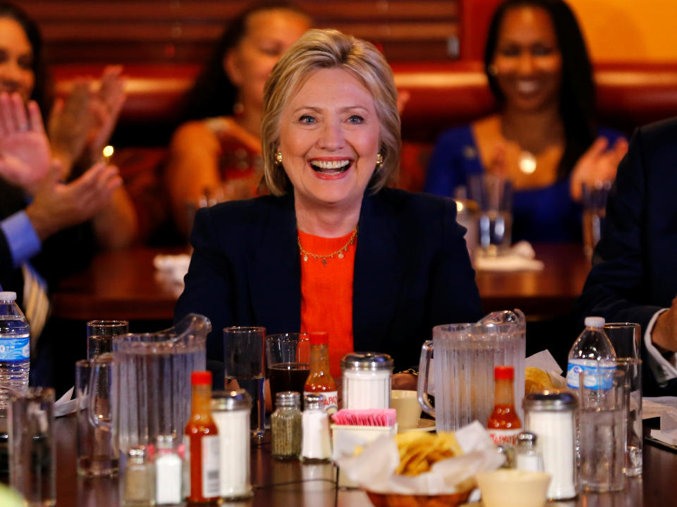 Clinton smiles&nbsp;amid hot sauce bottles while making a campaign stop at a restaurant in Perris, California on June 2, 2016. (Photo: Mike Blake / Reuters)