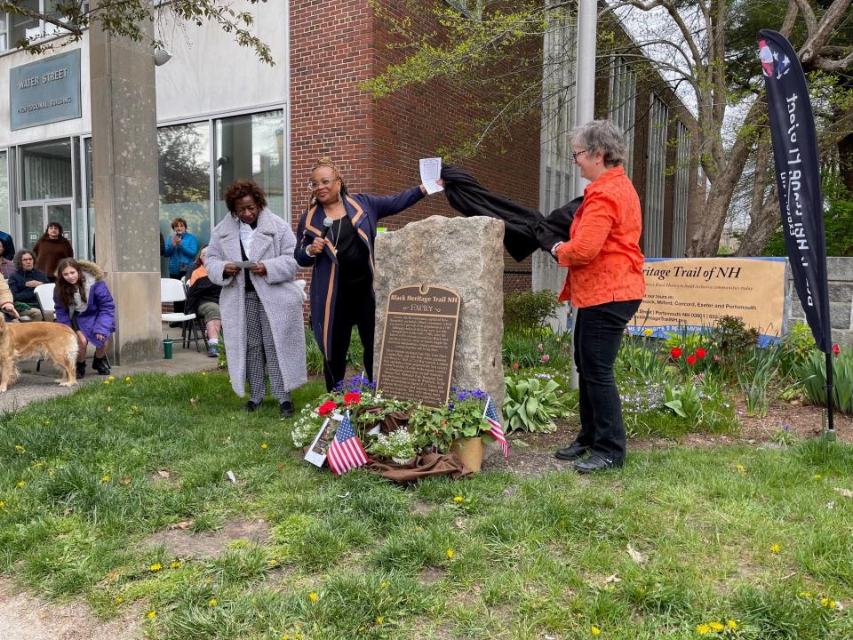 JerriAnne Boggis, executive director of the Black Heritage Trail of New Hampshire (center) and Exeter Historian Barbara Rimkunas (right) unveil an historic marker honoring Exeter's Black Revolutionary War community as civil rights activist and former state Rep. Jackie Weatherspoon (left) prepares to read the historic marker to the crowd Saturday, May 4, 2024.