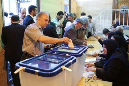 An Iranian man casts his vote into a ballot box during the presidential election in Tehran, Iran, May 19, 2017. TIMA via REUTERS