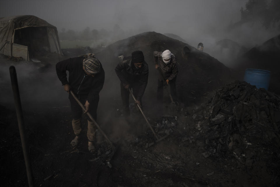 Palestinians work at a traditional charcoal production site in the town of Jabaliya, Northern Gaza Strip, Thursday, Jan. 7, 2021.(AP Photo/Khalil Hamra)