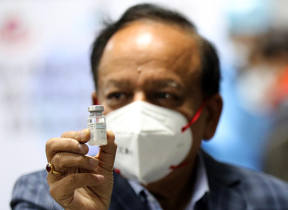 <p>India’s health minister Dr Harsh Vardhan holding Bharat Biotech’s Covid-19 vaccine, Covaxin, during the launch of the vaccination drive on 16 January</p> (EPA)