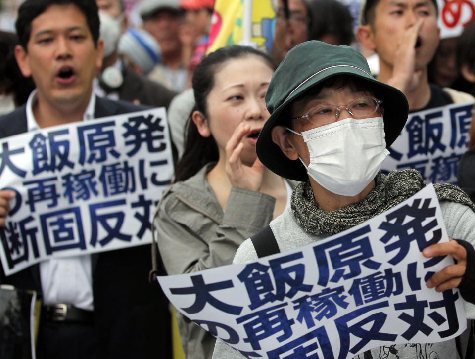 Protesters shout slogans during an anti-nuclear plant rally in front of the Prime Minister's office in Tokyo, Friday, June 8, 2012 shortly after Japanese Prime Minister Yoshihiko Noda said Japan must restart two nuclear reactors to protect the economy and people's livelihoods in a news conference. Noda said in the news conference broadcast live to the nation that the government has taken ample measures to ensure the safety of the two reactors at the Ohi nuclear plant in western Japan. The banners read "We strongly oppose restarting of the Ohi nuclear plant." (AP Photo/Itsuo Inouye)