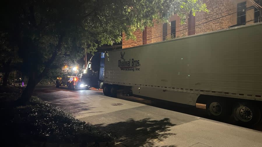 Damage to cars, street signs, etc. along East 9th Street near Embassy Drive after an 18-wheeler crashed into 10 parked vehicles overnight April 22, 2024 (KXAN Photo/Todd Bailey)