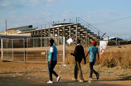 Locals walk past the White City Stadium, where Zimbabwe President Emmerson Mnangagwa escaped unhurt after an explosion rocked the stadium, in Bulawayo, Zimbabwe, June 23,2018. REUTERS/Philimon Bulawayo