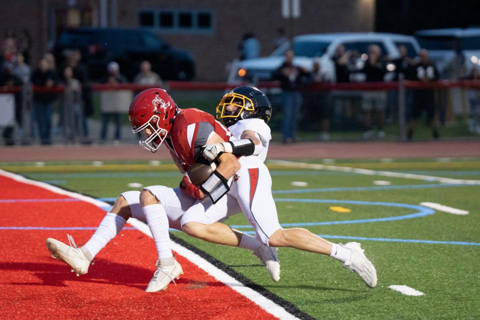 Sep 22, 2023; Wanaque, NJ, USA; West Milford football at Lakeland Regional High School. L #12 Sean Walker scores a touchdown after making a catch in the second quarter as WM # 14 Elijah Cosby tries to make the tackle. Mandatory Credit: Michael Karas-The Record