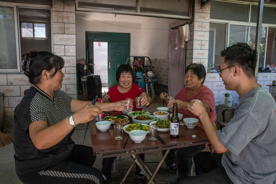Miembros de Sister Wang Is Coming almuerzan con el hijo de Wang Shuping, Ren Jixin, que pasa varios días a la semana escribiendo, ensayando y filmando para la banda, en Pekín, el 31 de agosto de 2022. (Gilles Sabrié/The New York Times)