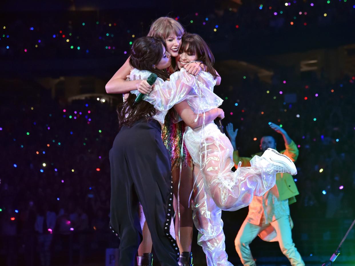 Taylor Swift hugs Camila Cabello and Charli XCX onstage during the Reputation Stadium Tour.