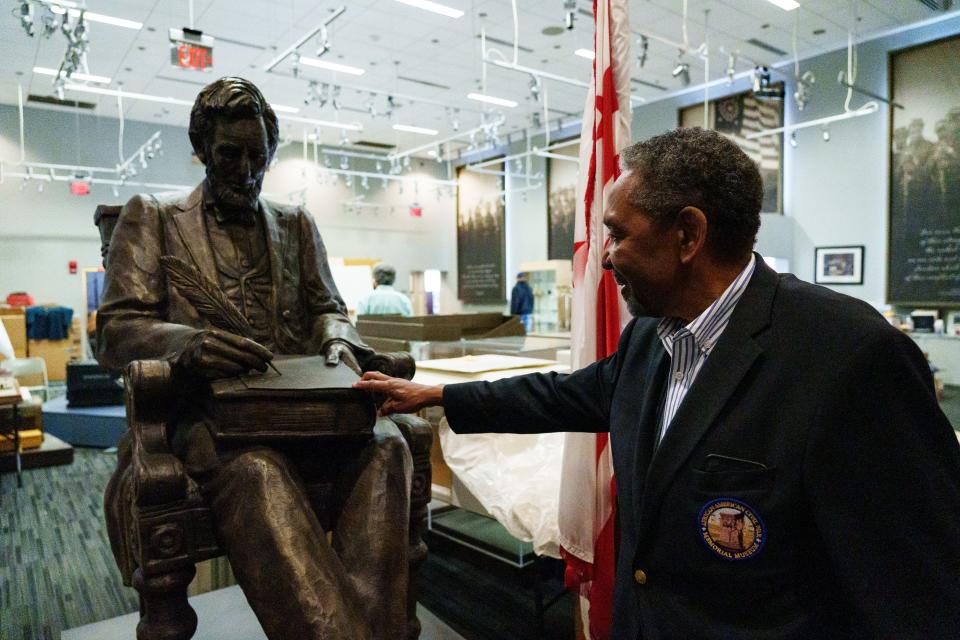 Frank Smith, the executive director of the African American Civil War Museum in Washington, D.C., shows a statue on May 11 of President Abraham Lincoln signing the Emancipation Proclamation that will be displayed in the museum's new location later this year. The museum will host a Juneteenth event dedicated to Black soldiers who fought in the Civil War.