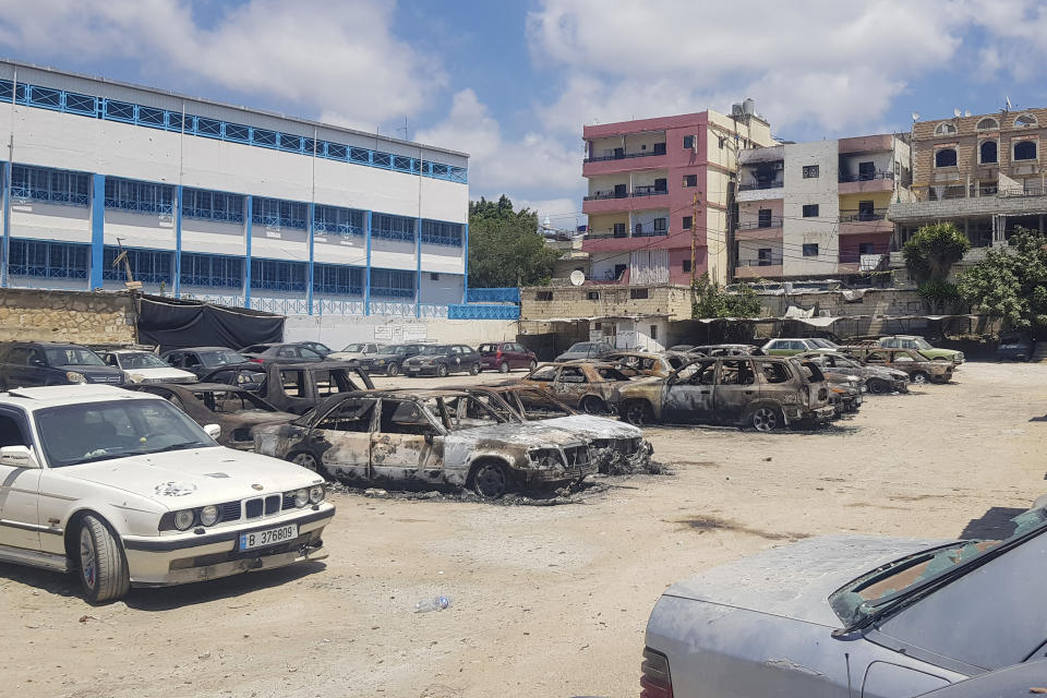 FILE - Charred remains of dozens of cars, burnt during the deadly clashes between Palestinian factions, are seen in front an UNRWA school, in the Palestinian refugee camp of Ein el-Hilweh near the southern port city of Sidon, Lebanon, Thursday, Aug. 3, 2023. Damages to the school complex in Lebanon's largest Palestinian refugee camp from clashes that erupted between factions in the camp over the past week could delay the start of the school year for some 6,000 children, the Lebanon head of the UN agency for Palestinian refugees said Friday. (AP Photo/Mohammad Zaatari, File)