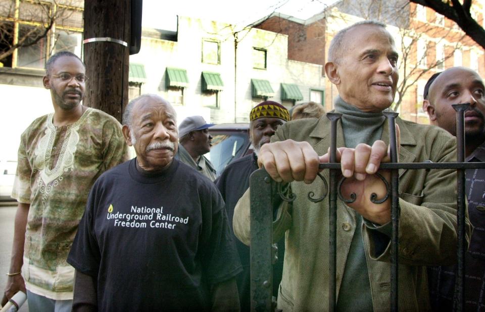 Harry Belafonte talks with a man sitting on the stoop near 15th and Elm in Over-The-Rhine during a National Underground Railroad Freedom Center march to New Prospect Baptist Church in 2001.