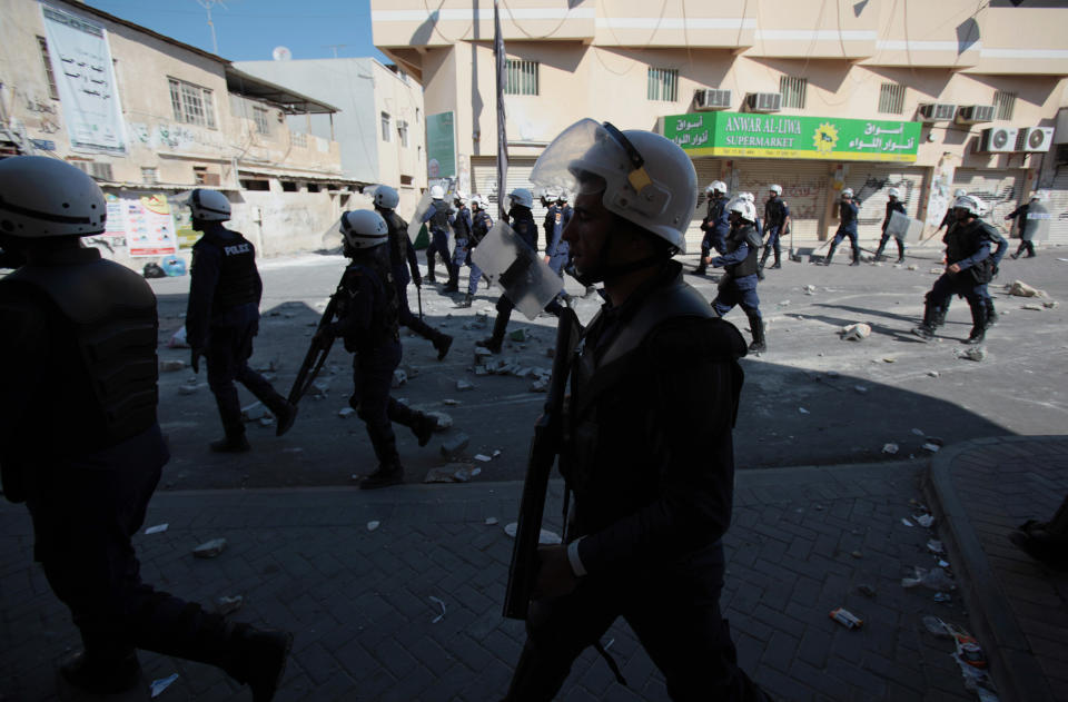 Bahraini riot police officers move toward anti-government protesters during clashes in Dih, on the edge of the capital of Manama, Bahrain, Friday, Feb. 14, 2014. An explosion rocked a bus carrying police in Bahrain on Friday, while security forces used tear gas in clashes with anti-government protesters on the third anniversary of an uprising in the small Gulf island nation. (AP Photo/Hasan Jamali)