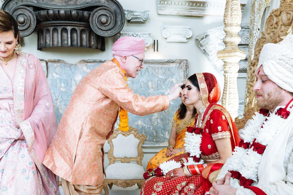 My dad commencing the Hindu ceremony by giving us Tilaka, marking our foreheads with red paste to symbolize his blessing.