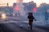A woman reacts on a street as tear gas is used by riot police to disperse protesters as demonstrations continue