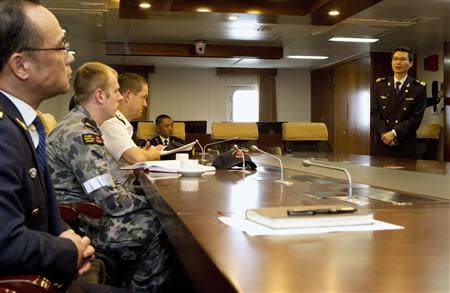 Commanding Officer of the Chinese Coast Guard vessel Haixun 01, Captain Jiang Long (R), gives a briefing to Senior Colonel Ma Liedong, Australian Navy Staff Officer Sub-Lieutenant Phillip Wagner, and Commander of Joint Task Force 658, Commodore Peter Leavy, (L-R) about the continuing search for the missing Malaysian Airlines flight MH370 in this picture released by the Australian Defence Force on April 17, 2014. REUTERS/Australian Defence Force/Handout