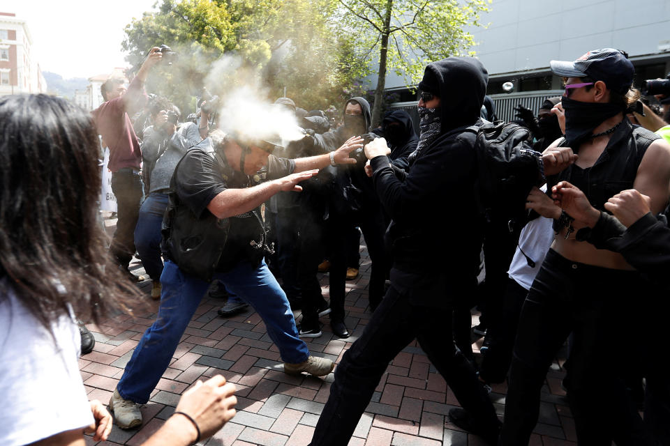 A man in support of U.S. President Donald Trump (L) is being pepper spray by a group on counter-protestor during a rally in Berkeley, California in Berkeley, California, U.S., April 15, 2017. REUTERS/Stephen Lam