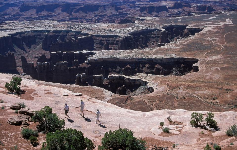 Hikers walk along Grand View Point at Canyonlands National Park