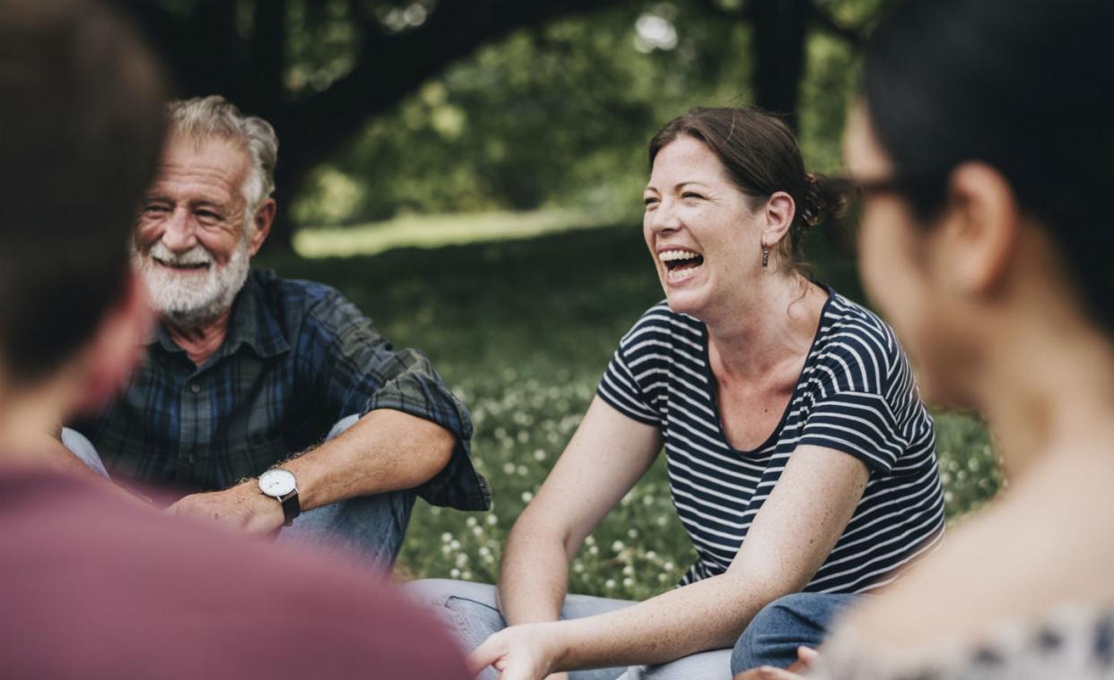 Photo of woman laughing in circle of friends