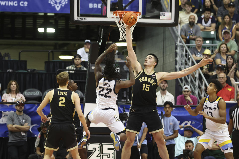 Purdue center Zach Edey (15) blocks a shot from Marquette guard Sean Jones (22) during the first half of an NCAA college basketball game, Wednesday, Nov. 22, 2023, in Honolulu. (AP Photo/Marco Garcia)