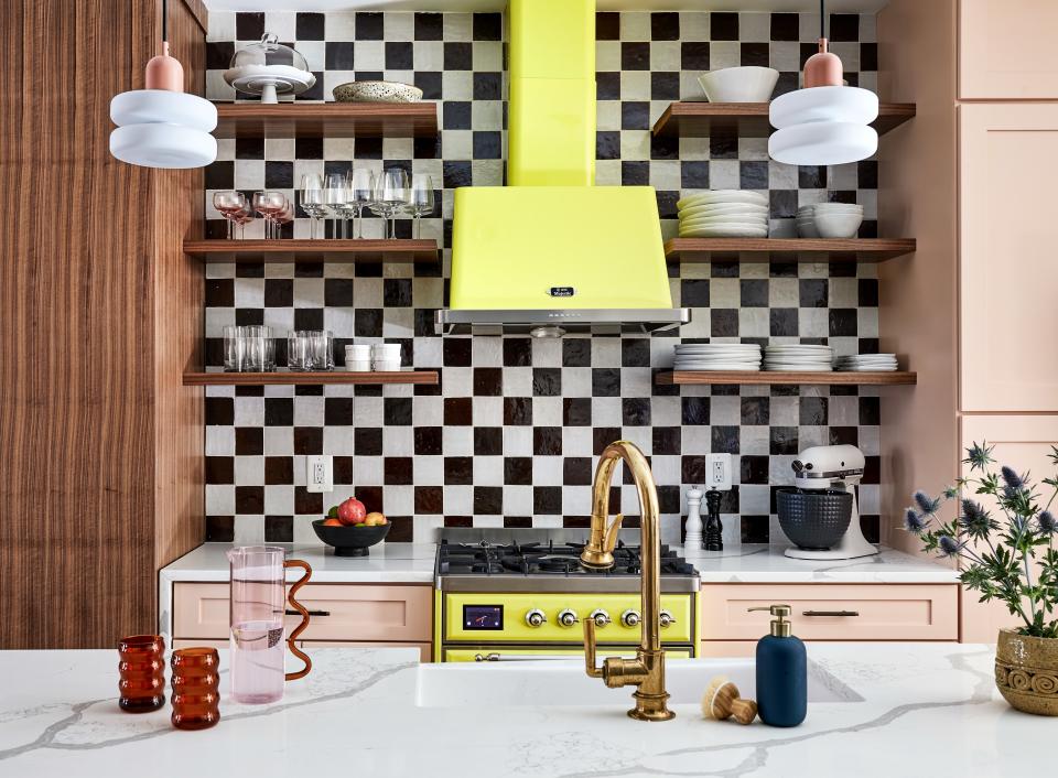 The kitchen is a kaleidoscope of retro chic. The tour de force is undoubtedly the sulfur yellow range and hood from Superior Marketing, although the checkerboard backsplash, characterized by four-inch tile in Clé’s Burnt Sugar and Weathered White, comes in a close second. The cabinets were custom-designed by Fajen & Brown and enlivened in Benjamin Moore’s Careless Whisper. Double Puck pendants by In Common With overarch the setting. The faucets are by Waterworks.