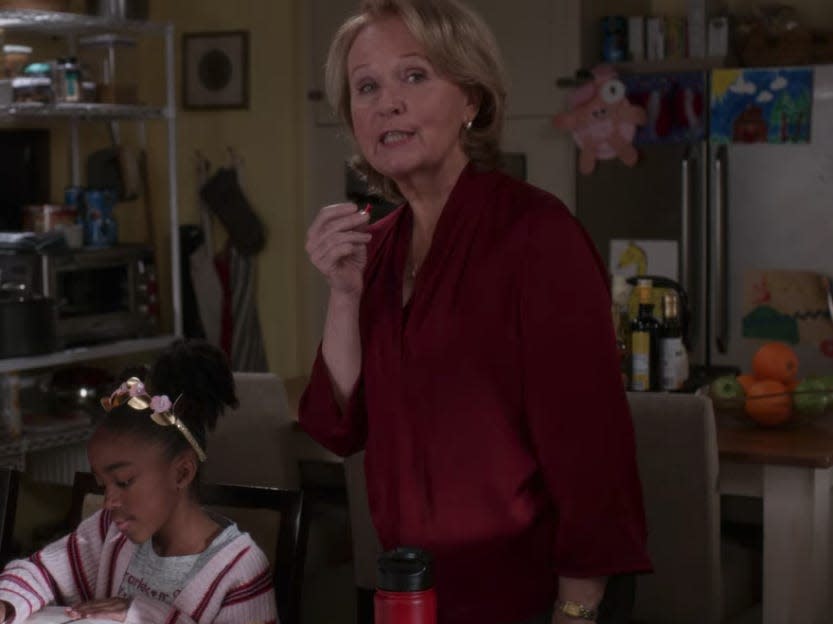 Kate Burton as Ellis Grey on Grey's Anatomy wearing red sweater in a living room