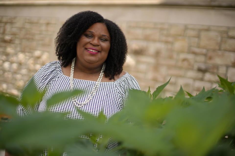 Emily Brown poses in a garden outside her office Wednesday, June 9, 2021, in Kansas City, Mo. Brown runs a nonprofit service to help families with food allergies access safe and healthy foods which she started after having difficulty obtaining food for her daughters who have numerous food allergies. (AP Photo/Charlie Riedel)