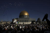 Palestinians celebrate on the first day of Muslim holiday of Eid al-Adha next to the Dome of the Rock shrine at the Al Aqsa Mosque compound in Jerusalem's Old City, Saturday, July 9, 2022. The major Muslim holiday, at the end of the hajj pilgrimage to Mecca, is observed around the world by believers and commemorates prophet Abraham's pledge to sacrifice his son as an act of obedience to God. (AP Photo/Mahmoud Illean)