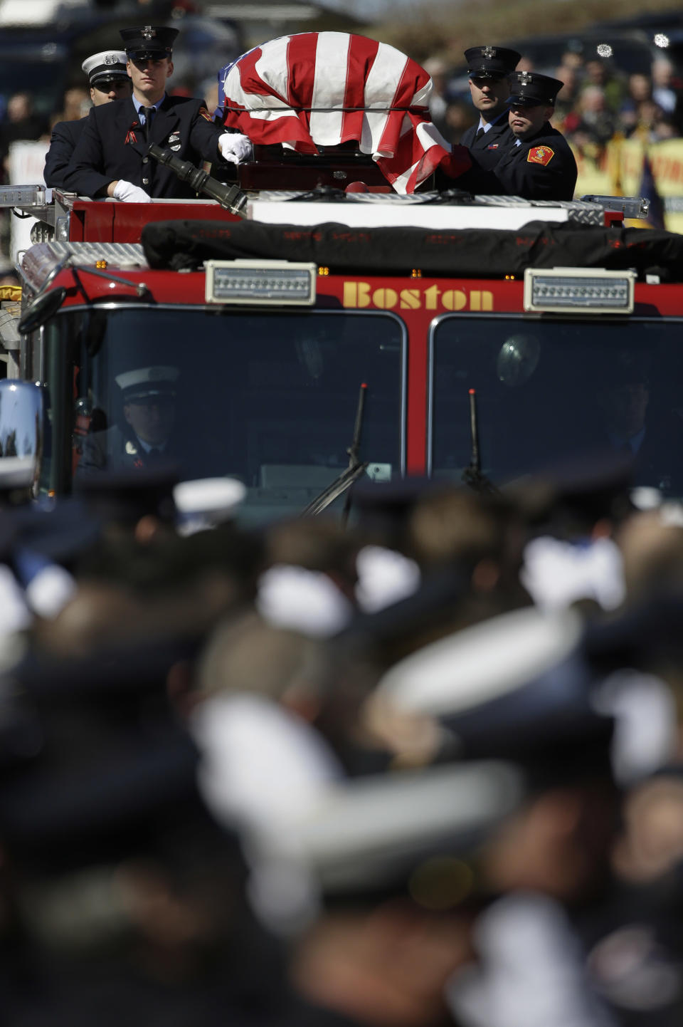 The funeral procession for Boston firefighter Michael R. Kennedy proceeds through saluting firefighters as it approaches Holy Name Church in Boston, Thursday, April 3, 2014. Kennedy and Boston Fire Lt. Edward J. Walsh were killed Wednesday, March 26, 2014 when they were trapped in the basement of a burning brownstone during a nine-alarm blaze.(AP Photo/Stephan Savoia)