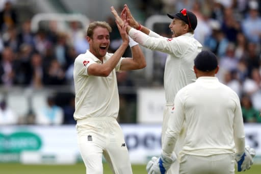 England's Stuart Broad (L) celebrates with captain Joe Root after taking the wicket of India's Dinesh Karthik during play on the fourth day of the second Test at Lord's Cricket Ground in London on August 12, 2018